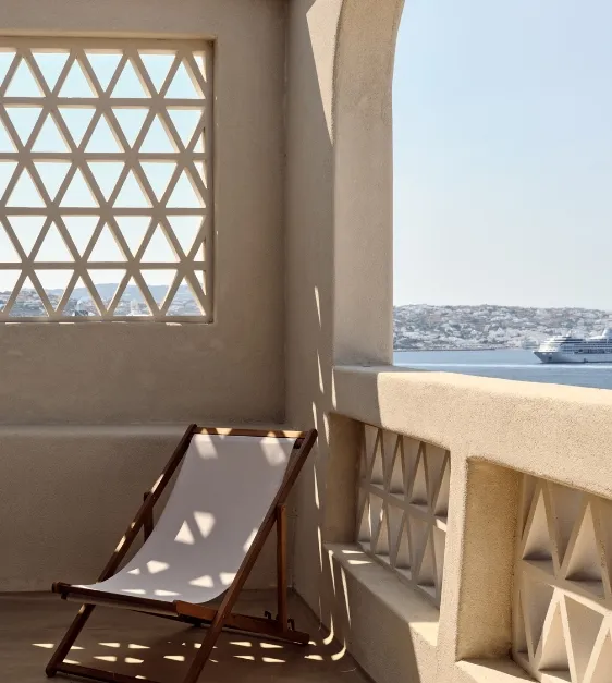 A chair on a balcony with a breathtaking ocean view